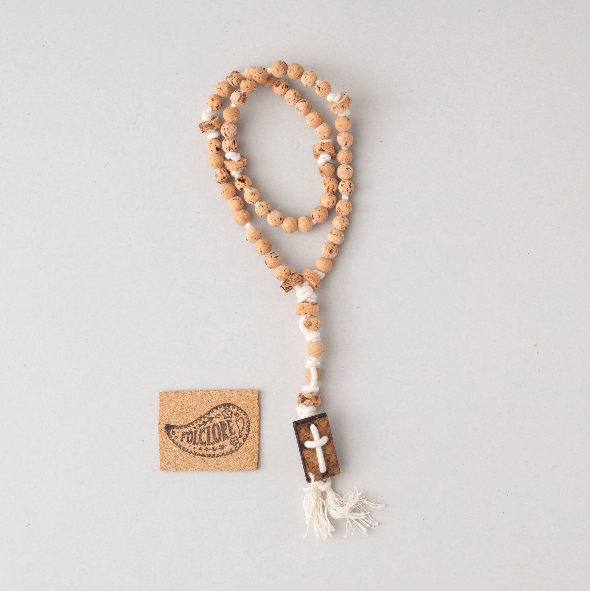 beaded cork rosary in off-white folded with exclusive cork cross